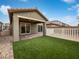 Landscaped backyard with artificial turf, covered patio, and white fence at 10425 Seelos St, Las Vegas, NV 89178