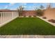 Artificial turf backyard with a brick wall and white fence at 10425 Seelos St, Las Vegas, NV 89178