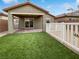 Backyard with covered patio, artificial turf, and white fence at 10425 Seelos St, Las Vegas, NV 89178