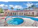 Resort-style community pool with palm trees and building with red tile roof at 10550 W Alexander Rd # 1007, Las Vegas, NV 89129