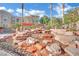 A community water feature surrounded by lush landscaping including palm trees in a rock garden at 10550 W Alexander Rd # 1007, Las Vegas, NV 89129