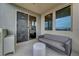 Cozy balcony with a modern gray sofa, and large windows showcasing a scenic view at 11250 Hidden Peak Ave # 208, Las Vegas, NV 89135