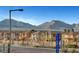 Street view of community homes with desert landscaping, mountain views, and community signage at 11250 Hidden Peak Ave # 208, Las Vegas, NV 89135