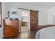 Bedroom with ensuite bathroom featuring a rustic barn door and rich hardwood floors at 11518 Belmont Lake Dr # 104, Las Vegas, NV 89135