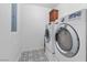 Modern laundry room features side-by-side washer and dryer and patterned tile flooring at 11518 Belmont Lake Dr # 104, Las Vegas, NV 89135