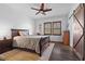 Serene main bedroom features a ceiling fan, wooden floors, and a stylish sliding barn door at 11518 Belmont Lake Dr # 104, Las Vegas, NV 89135