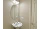 Cozy half-bathroom with modern light fixture and oval mirror at 12048 La Palmera Ave, Las Vegas, NV 89138