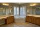 Bright bathroom features dual sinks, a large soaking tub, and natural light from shuttered windows at 12048 La Palmera Ave, Las Vegas, NV 89138