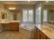 Bright bathroom features dual sinks, a large soaking tub, and natural light from shuttered windows at 12048 La Palmera Ave, Las Vegas, NV 89138