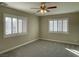 Neutral bedroom featuring shuttered windows, carpeted floor, and a ceiling fan at 12048 La Palmera Ave, Las Vegas, NV 89138