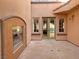 Exterior courtyard with built-in fireplace and access to the home through glass doors at 12048 La Palmera Ave, Las Vegas, NV 89138