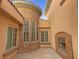 Exterior courtyard showcasing stone accents, a fireplace, and multiple windows at 12048 La Palmera Ave, Las Vegas, NV 89138