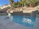 A gorgeous, refreshing pool with water features surrounded by desert landscaping at 12048 La Palmera Ave, Las Vegas, NV 89138