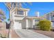 Two-story house with a one-car garage, driveway and mature landscaping at 122 Boysenberry Ln, Henderson, NV 89074