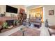 Living room with brick fireplace, brown leather furniture, and large TV at 122 Boysenberry Ln, Henderson, NV 89074