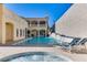 An amazing backyard pool with hot tub and waterfall feature in a gorgeous luxury outdoor living space at 1245 S Rancho Dr, Las Vegas, NV 89102