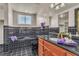 Well-lit bathroom features black tile, granite countertops, and a single sink vanity at 1245 S Rancho Dr, Las Vegas, NV 89102