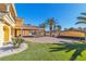 Rear view of home with turf, tropical foliage, and brick driveway at 1245 S Rancho Dr, Las Vegas, NV 89102