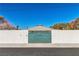 Green entry gate with a high stucco wall for security at 1245 S Rancho Dr, Las Vegas, NV 89102