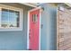 Charming home entrance featuring a coral front door, a window and a modern outdoor lighting fixture at 139 Ivy St, Henderson, NV 89015