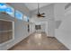 High-ceiling living room with tile floors and a ceiling fan and large windows at 204 Appian Way, Henderson, NV 89002