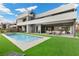 An expansive backyard shows a modern pool, well manicured grass, outdoor seating, and access to a spiral staircase at 21 Canyon Bay Dr, Henderson, NV 89011