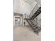 A modern home's staircase features metal railings, tile floors, high ceilings, and a view of a decorative console at 21 Canyon Bay Dr, Henderson, NV 89011