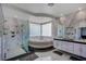 Elegant bathroom with marble walls, a jacuzzi tub, a glass-enclosed shower, and dual vanities at 2200 Nordica Ct, Las Vegas, NV 89117