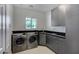 Well-equipped laundry room with modern washer and dryer, stylish cabinets, and ample counter space at 2200 Nordica Ct, Las Vegas, NV 89117