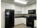 Galley kitchen with white cabinets, black appliances, and gray countertops and vinyl plank flooring at 2420 Sweetgum St, Las Vegas, NV 89108