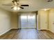 Bright living room featuring vinyl plank flooring, ceiling fan, and sliding glass door to backyard at 2420 Sweetgum St, Las Vegas, NV 89108