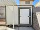 Exterior shot of white backyard storage shed, with brown trim and a white door at 2420 Sweetgum St, Las Vegas, NV 89108