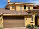 Two-story home showcases a brown tile roof, a tan exterior, and two-car garage at 25 Via Mantova # 2, Henderson, NV 89011