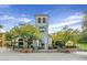 Charming exterior of a commercial building with beautiful stonework, outdoor seating, and lush landscaping at 25 Via Mantova # 2, Henderson, NV 89011