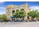 Beautiful yellow commercial building featuring outdoor seating, blue awnings, and decorative balconies at 25 Via Mantova # 2, Henderson, NV 89011