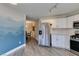 Bright kitchen with stainless steel refrigerator, white cabinets, stainless steel range and stylish flooring at 3663 Laguna Verde Way, Las Vegas, NV 89121