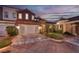 Exterior of home with two-car garage, landscaping, and sunset view at 38 Strada Principale, Henderson, NV 89011