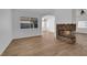 Spacious living room featuring a stone fireplace, wood-look flooring, and ample natural light from a large window at 3923 Gramercy Ave, North Las Vegas, NV 89031