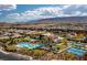 Aerial view showcases the community pool, tennis courts, and lush landscaping with mountain views at 4342 Guava Ct # 0, Las Vegas, NV 89135