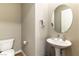 Well-lit powder room with pedestal sink and round mirror at 4342 Guava Ct # 0, Las Vegas, NV 89135