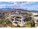 Luxury home featuring multiple pools and balconies, with views of the surrounding mountains at 4929 Summit Overlook Dr, Las Vegas, NV 89135