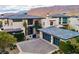 Expansive desert home featuring an oversized driveway and glass garage doors at 4929 Summit Overlook Dr, Las Vegas, NV 89135