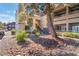 Exterior view of apartment complex featuring trees and manicured landscaping at 5046 S Rainbow Blvd # 103, Las Vegas, NV 89118