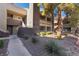 Exterior view of the apartment complex featuring trees and manicured landscaping at 5046 S Rainbow Blvd # 103, Las Vegas, NV 89118