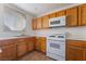 Functional kitchen with wood cabinetry, white appliances, and tile floors, ready for cooking at 5046 S Rainbow Blvd # 103, Las Vegas, NV 89118