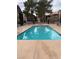 Community pool with surrounding trees and fence at 5046 S Rainbow Blvd # 103, Las Vegas, NV 89118