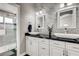 Modern bathroom with double vanity, black granite countertop, and frameless shower at 5448 Red Sun Dr, Las Vegas, NV 89149