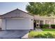 Front view of a single-story house with a white exterior, a two-car garage, and a nicely landscaped front yard at 5448 Red Sun Dr, Las Vegas, NV 89149