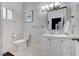 Simple bathroom with white vanity, toilet and a shower at 5880 W Oquendo Rd, Las Vegas, NV 89118