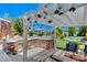 Outdoor kitchen with brick grill, granite countertops, and pergola at 5880 W Oquendo Rd, Las Vegas, NV 89118